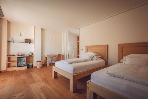 a bedroom with two beds and a table and a fireplace at Agriturismo La Pertica in Costermano sul Garda