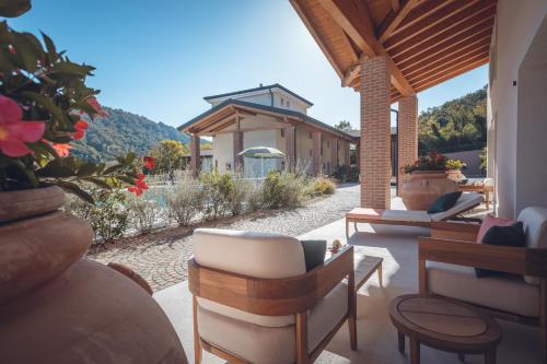 a patio with chairs and tables and a building at Agriturismo La Pertica in Costermano sul Garda
