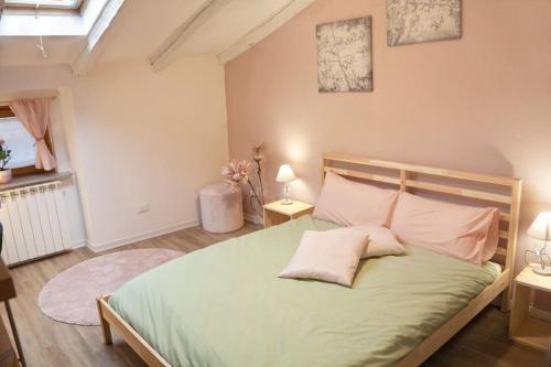 a bedroom with a large green bed with two pillows at La mansardina in Trieste