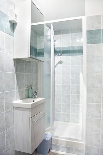a white bathroom with a shower and a sink at La mansardina in Trieste