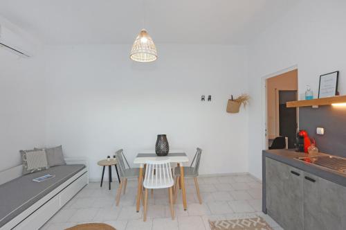 a kitchen with a table and chairs in a room at Galini Rooms & Apartments in Finikas