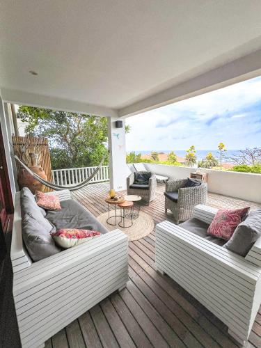 a patio with couches and a hammock on a deck at Luxe zeezicht appartement Bayside, Jan Thiel Boca Gentil in Willemstad