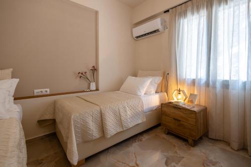 a small bedroom with a bed and a window at Southern Light Tsoutsouros in Tsoútsouros