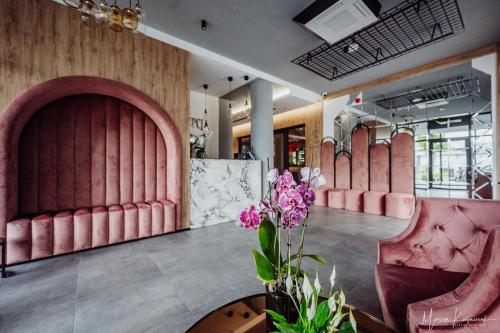 a salon with pink chairs and a table and flowers at Cristal in Ustka