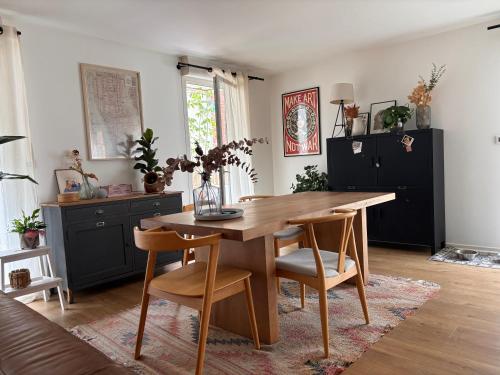 une salle à manger avec une table et des chaises en bois dans l'établissement Chambre cosy et paisible, à Lille