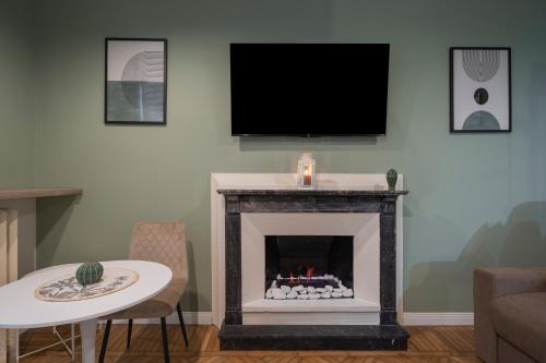 a living room with a fireplace with a flat screen tv at Loreto Prestige - Parking Free & Bulb Gym in Milan