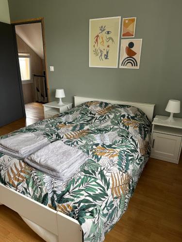 - une chambre avec un lit et une couverture colorée dans l'établissement Le Boichot, à Dole