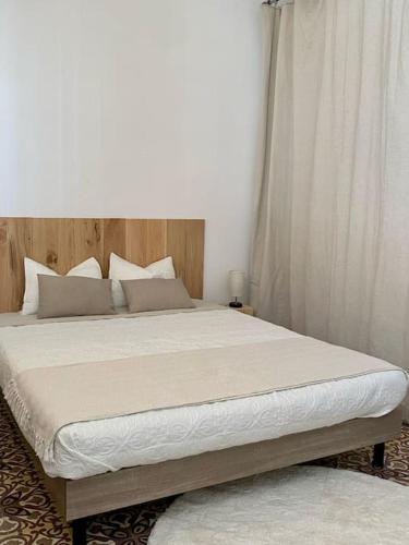 une chambre avec un grand lit avec une tête de lit en bois dans l'établissement Jacuzzi Clim Proche Centre, à Avignon