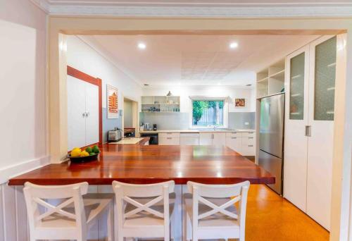 a kitchen with a large wooden table and white chairs at Havehus in Denmark