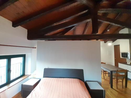 a bedroom with a bed and a table and windows at I Personaggi in Udine