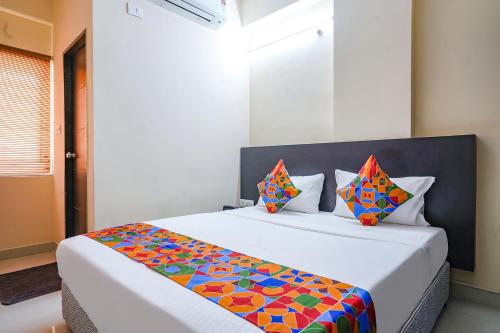 a bedroom with a large bed with a colorful blanket at FabHotel Serenity - Nr AIG Hospital, Gachibowli in Gachibowli