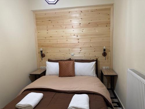 a bedroom with a bed with a wooden headboard at Vachos 1 in Arachova