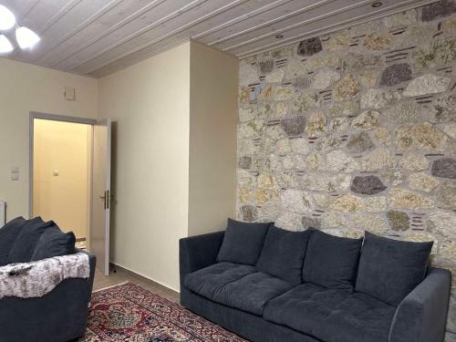 a living room with a couch and a stone wall at Vachos 1 in Arachova