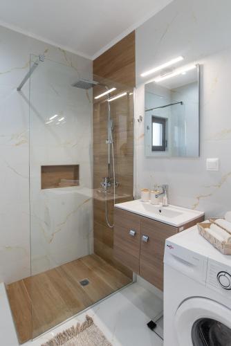 a bathroom with a shower and a sink and a washing machine at Casa Manou - Kalyves beach in Kalyves