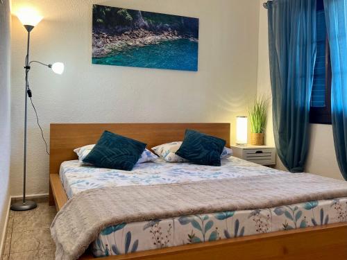 サンミゲル・デ・アボナにあるPenthouse in Golf del Sur 2の青い枕が付いたベッドのある寝室