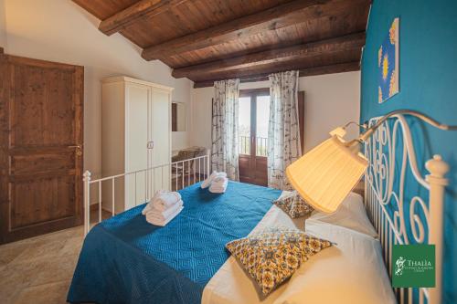 チェファルにあるThalia apartaments Cefalùのベッドルーム1室(ブルーベッド1台、タオル付)