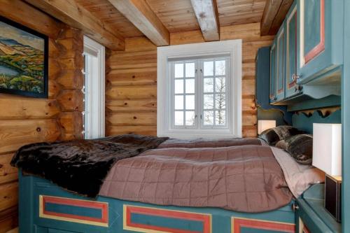 a bedroom with a bed in a log cabin at Cozy family cabin with stunning location on Golsfjellet in Golsfjellet