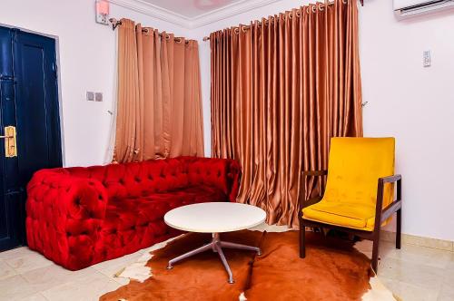 a living room with a red couch and a yellow chair at Haven Heights Apartments in Lagos