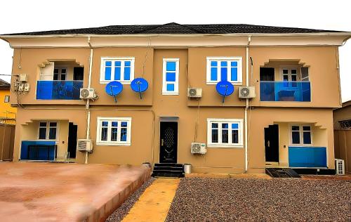 a large yellow building with blue doors and windows at Haven Heights Apartments in Lagos