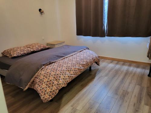 a bedroom with two beds and a wooden floor at Gite Le Creusot - 4 Chambres individuelles in Le Breuil