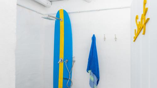 a surfboard hanging on a wall next to scissors at Bliss on the Bay in Struisbaai