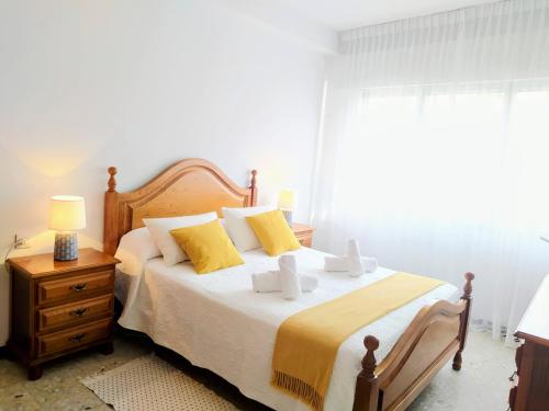 a bedroom with a large bed with yellow pillows at Alojamiento Caldas Centro in Caldas de Reis