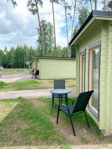 a table and a chair next to a green house at Taevaskoja Salamaa Camping in Taevaskoja