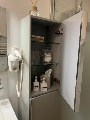 une salle de bain avec une armoire blanche avec un téléphone dans l'établissement Gruissan HUBLOTS DU PORT, à Gruissan