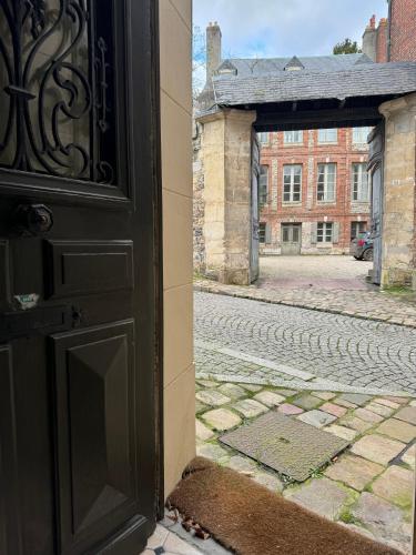 une porte ouverte d'un vieux bâtiment avec une rue dans l'établissement Maison de ville proche du port au cœur du Carré des Arts de Honfleur, à Honfleur