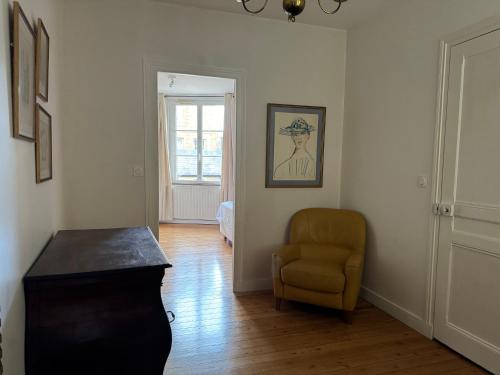 un salon avec une chaise et une table dans l'établissement Maison de ville proche du port au cœur du Carré des Arts de Honfleur, à Honfleur