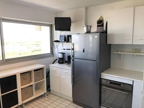 Il comprend une cuisine équipée d'un réfrigérateur et d'une fenêtre. dans l'établissement Quartier Couchant Studio cabine pour 6 personnes N102, à La Grande Motte