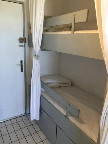 Cette chambre comprend 2 lits superposés et une porte. dans l'établissement Quartier Couchant Studio cabine pour 6 personnes N102, à La Grande Motte
