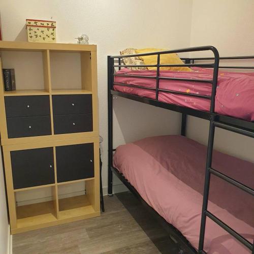 Cette chambre comprend 2 lits superposés et une étagère. dans l'établissement Quartier couchant Appartement t2 cabine pour 4 personnes N107, à La Grande Motte