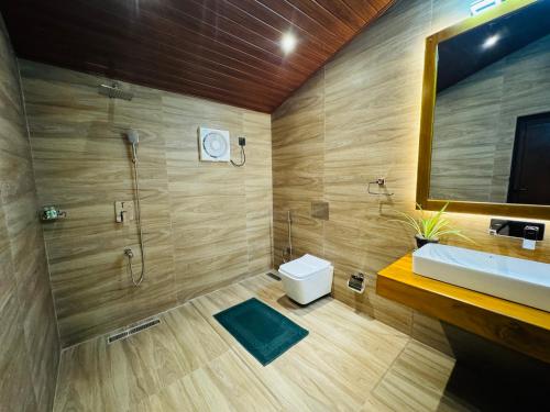 a bathroom with a shower and a toilet and a sink at Hotel River Front in Tissamaharama