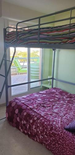 une chambre avec un lit superposé et une fenêtre dans l'établissement Coeur de ville avec piscine Appartement t4 pour 6 personnes N113, à La Grande Motte