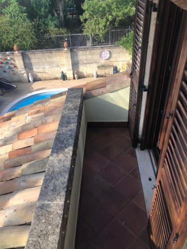 a swimming pool with a retaining wall and a patio at Apulia House in Bisceglie