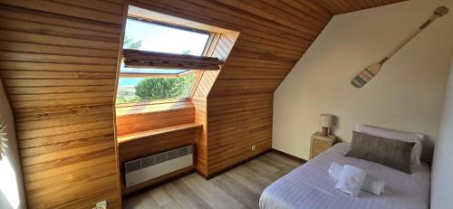 a bedroom with a bed and a large window at Maison vue mer Crozon - Jacuzzi - Sauna in Crozon