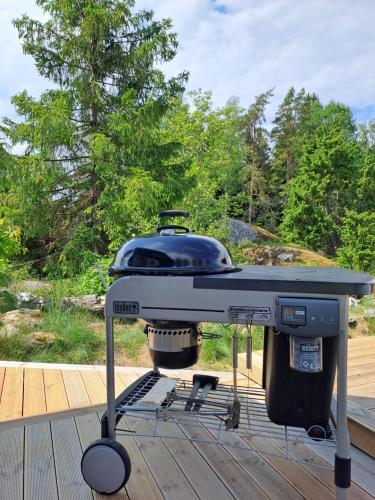 a grill sitting on top of a deck at Stuga på landet med egen pool, vedeldad badtunna och bastu in Tungelsta