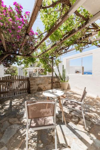 a patio with a table and chairs under a pergola at Rania Apartments Sea View in Mýkonos City