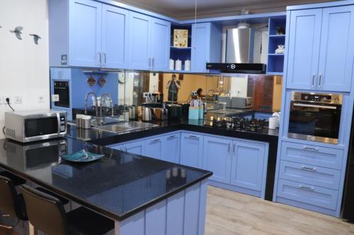 a kitchen with blue cabinets and a black counter top at Villa Munjul Indah - Majalengka in Jatipamor