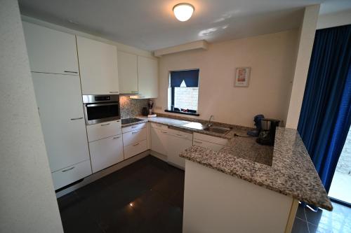 a kitchen with white cabinets and a counter top at Résidence Durbuy in Durbuy