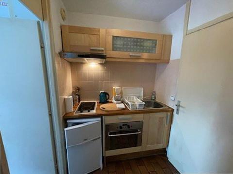 Il comprend une petite cuisine équipée d'une cuisinière et d'un évier. dans l'établissement Quartier Couchant Appartement studio pour 2 personnes N2 121, à La Grande Motte