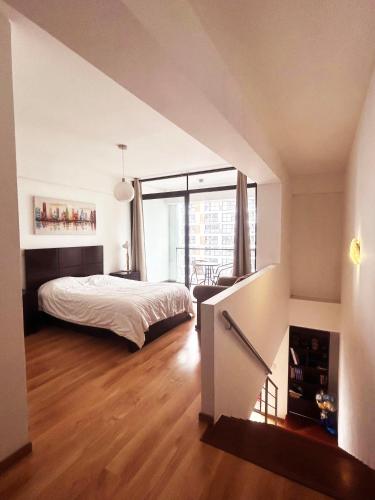 a bedroom with a bed and a large window at Apartamento dúplex exclusivo y céntrico in Lima