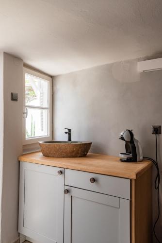 a kitchen counter with a bowl sink on top of it at Rania Apartments Sea View in Mýkonos City
