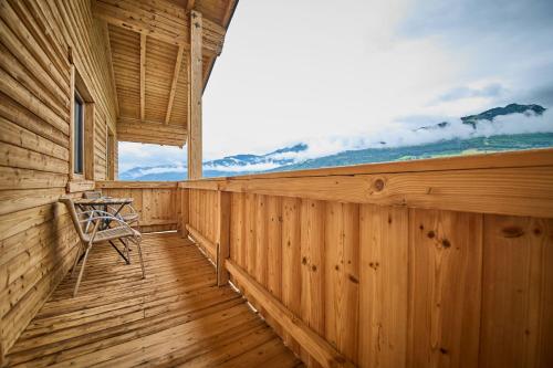 a wooden porch with a chair on a deck at Platzhirsch Rooms - B&B - SELF CHECK-IN in Piesendorf