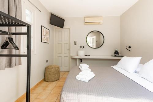 a bedroom with a bed and a mirror at Rania Apartments Sea View in Mýkonos City