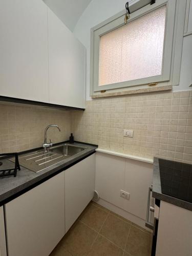 a kitchen with a sink and a window at Casa nel Vicolo - Duomo di Osimo e 20 min da Loreto in Osimo