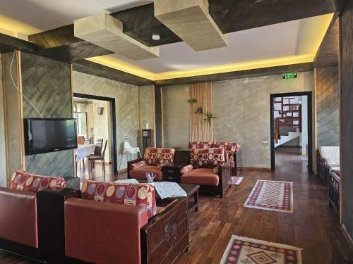 a living room with couches and a flat screen tv at Belvedere Resort Moieciu in Moieciu de Jos