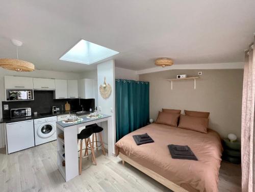 une petite chambre avec un lit et une cuisine dans l'établissement Jardins de Castille - 200m de la gare - Home cinéma, à Amiens