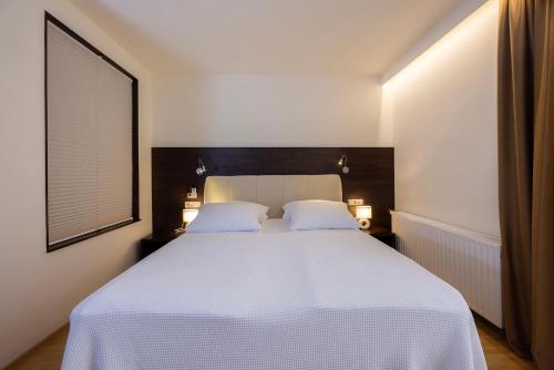 a bedroom with a white bed with two white pillows at Rooms Bella in Bled